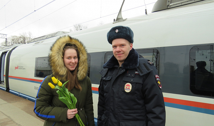 На железнодорожном вокзале в Твери полицейские вручают цветы женщинам
